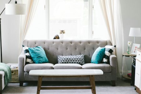 Gray tufted sofa with a marble-top wood coffee table